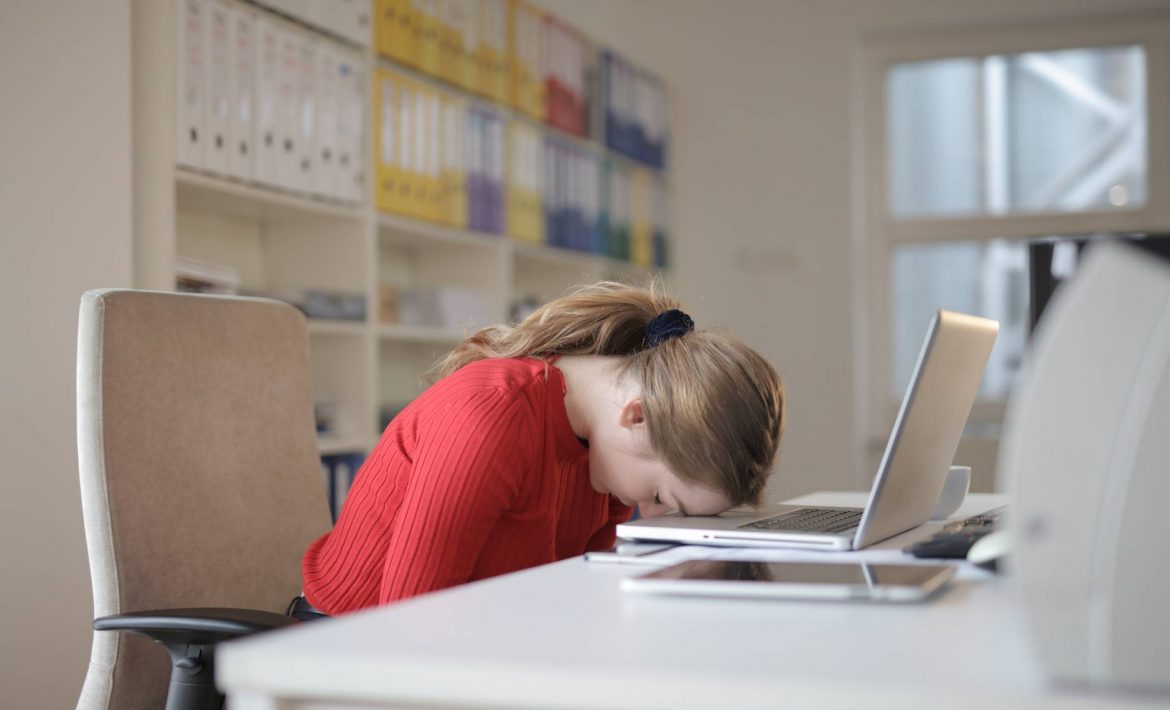 woman sitting on chair while leaning on laptop